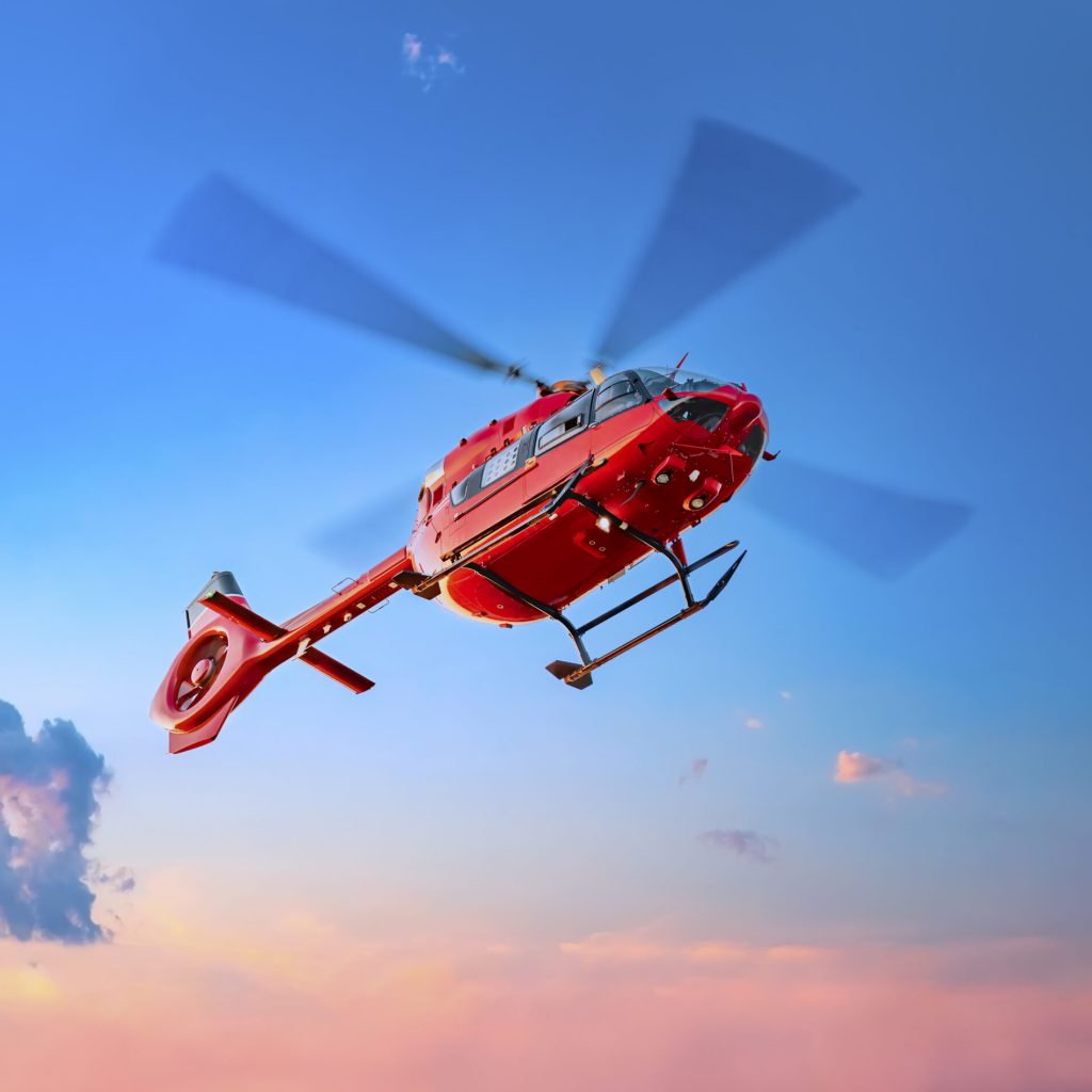 Red color helicopter in the air. Great photo on the theme of air medical service, air transportation,  air ambulance,  fast city transportation or helicopter tours.