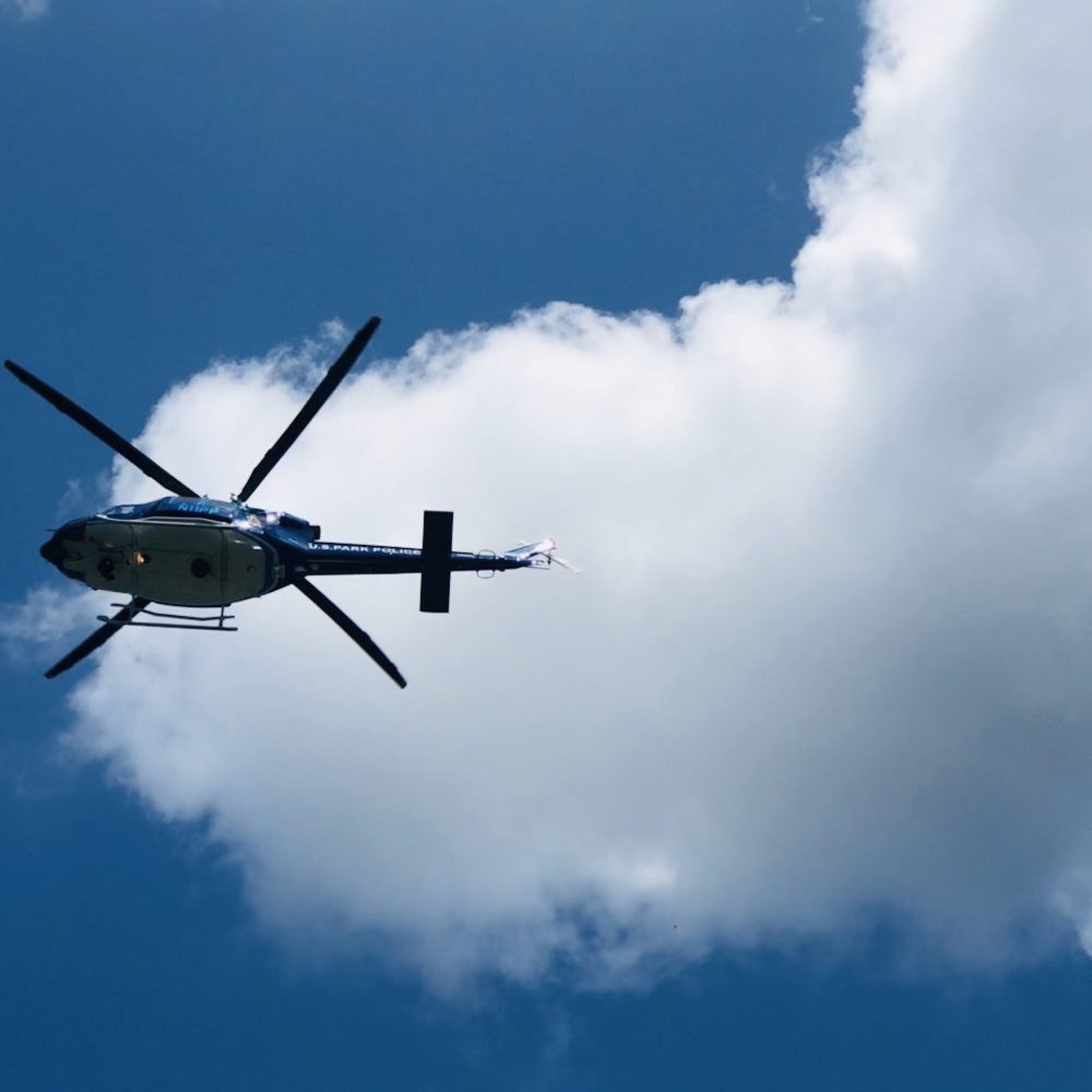 helicopter-flying-overhead-against-blue-sky-and-wh-2024-11-02-00-50-08-utc